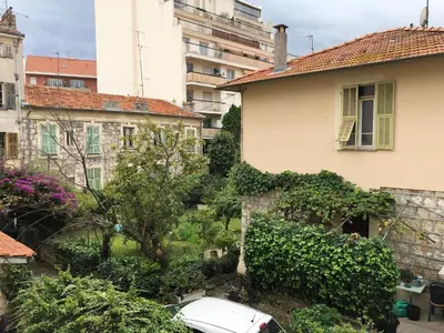 a building with a car parked in a yard at Nice Libération in Nice