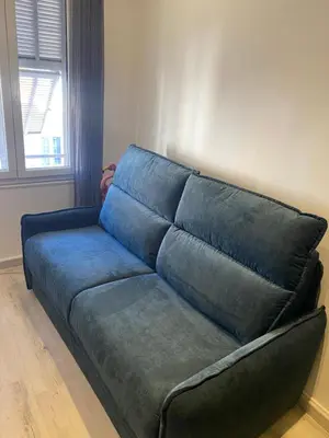 a blue couch sitting in a living room at Rentomatique Studio Jean Médecin in Nice