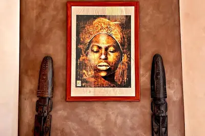 a wall with a picture of a woman and two guns at Au Petit Bourgeois in Nice