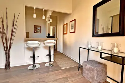 a room with a mirror and two stools and a table at Au Petit Bourgeois in Nice