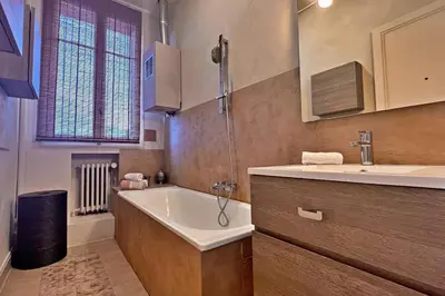 a bathroom with a bath tub and a sink at Au Petit Bourgeois in Nice
