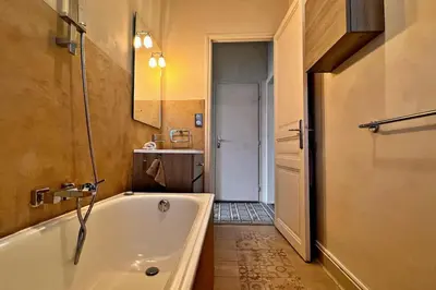 a bathroom with a tub and a sink and a mirror at Au Petit Bourgeois in Nice