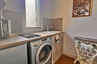 a laundry room with a washing machine and a sink at Au Petit Bourgeois in Nice