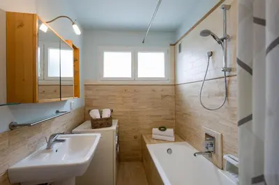 a bathroom with two sinks and a tub and a shower at Ferienwohnung Les Oliviers über den Dächern von Nizza ruhig sonnig Meerblick Pool Tiefgarage Parkplatz in Nice