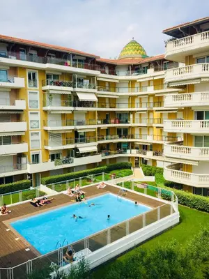 an apartment building with a swimming pool in front of it at Palais des Domes Piscine et Parking in Nice