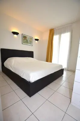 a bedroom with a large bed in a room at Palais des Domes Piscine et Parking in Nice