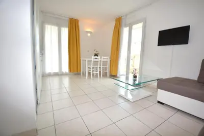 a living room with a couch and a glass table at Palais des Domes Piscine et Parking in Nice