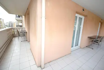 a room with a balcony with a table and chairs at Palais des Domes Piscine et Parking in Nice