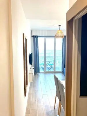 a living room with a table and a large window at Residence le Florence in Nice