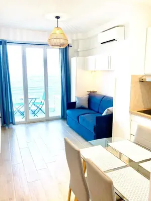 a living room with a blue couch and a table at Residence le Florence in Nice