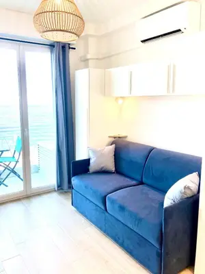 a blue couch in a living room with a balcony at Residence le Florence in Nice