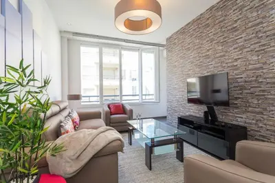 a living room with a tv and a brick wall at Royal apartment near the beaches in Nice