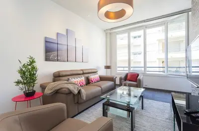 a living room with a couch and a table at Royal apartment near the beaches in Nice