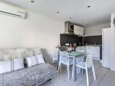 a kitchen and living room with a table and a couch at Apartment Le Marbeau-2 by Interhome in Cagnes-sur-Mer