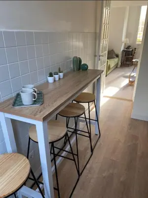 a kitchen with a table with stools and a counter top at Studio Nice Le Palais, avec cuisine et espace repas séparés, dans immeuble niçois, Port de Nice, Vieux Nice, Place du pin et Garibaldi, Colline du château, à 2 minutes de la promenade des Anglais in Nice