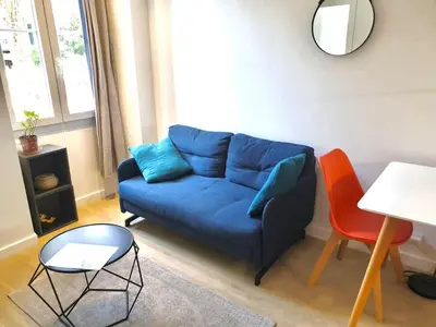 a living room with a blue couch and a table at Homelivia, Votre Appartement ideal pour découvrir Nice in Nice