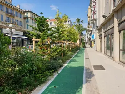 a street with a green path in a city at Homelivia, Votre Appartement ideal pour découvrir Nice in Nice