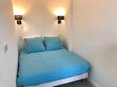 a small bed in a room with two blue pillows at Homelivia, Votre Appartement ideal pour découvrir Nice in Nice