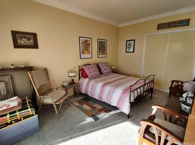 a bedroom with a bed and a chair at Vintage flat on Villefranche bay - free car park in Villefranche-sur-Mer
