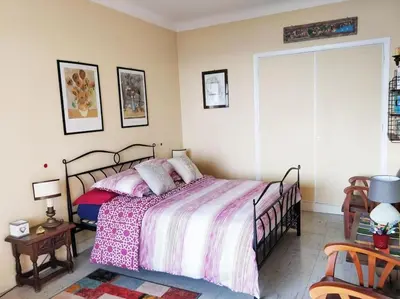 a bedroom with a bed with a pink comforter at Vintage flat on Villefranche bay - free car park in Villefranche-sur-Mer
