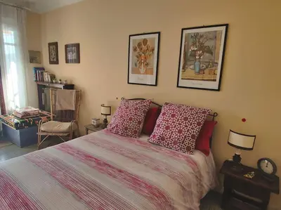 a bedroom with a bed with red pillows at Vintage flat on Villefranche bay - free car park in Villefranche-sur-Mer