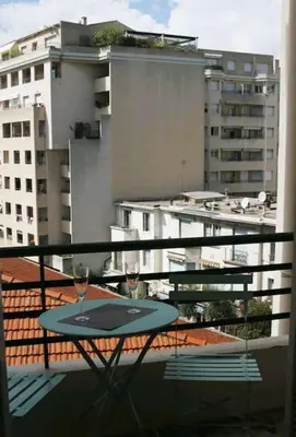 a table on a balcony with two wine glasses at Central, climatisé, proche Promenade des anglais. in Nice