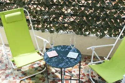 two green chairs and a table with two wine glasses at Central, climatisé, proche Promenade des anglais. in Nice