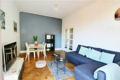 a living room with a blue couch and a table at Central, climatisé, proche Promenade des anglais. in Nice