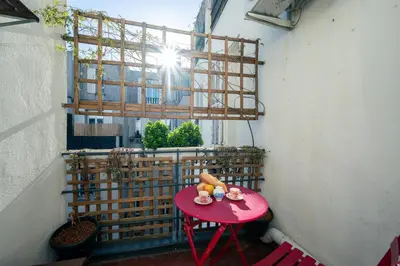a shelf with a red bottle and a lamp and books at LX191 2P design & coloré face gare - Balcon & clim in Nice