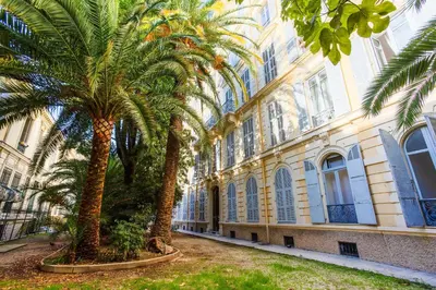 a row of palm trees in front of a building at LE PALAZZO AP4329 By Riviera Holiday Homes in Nice