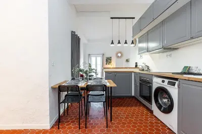 a kitchen with a table with chairs and a washing machine at Lovely 1 Bdr in Harbor Area in Nice