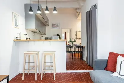 a kitchen and living room with a counter and stools at Lovely 1 Bdr in Harbor Area in Nice