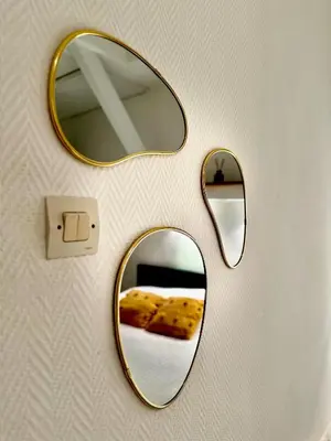 a pair of mirrors on a wall with a piece of pizza at Romantique - NeaSpace Vieux Nice in Nice