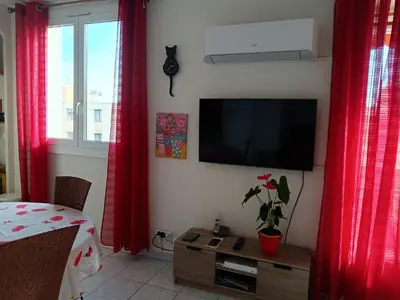 a living room with red curtains and a flat screen tv at NICE NORD 2 PIECES CALMES,WIFI,CLIM,BALCON,PARKING in Nice