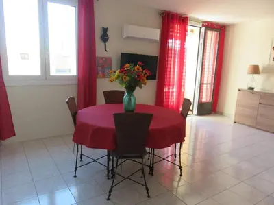 a dining room table with a vase of flowers on it at NICE NORD 2 PIECES CALMES,WIFI,CLIM,BALCON,PARKING in Nice