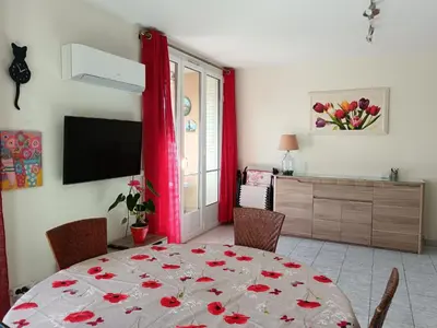 a dining room with a table with a red curtain at NICE NORD 2 PIECES CALMES,WIFI,CLIM,BALCON,PARKING in Nice