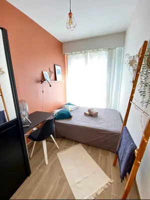 a bedroom with a bed and a desk and a window at Cosy Californie in Nice