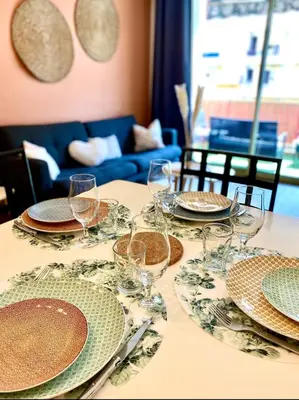 a table with plates and wine glasses on it at Cosy Californie in Nice