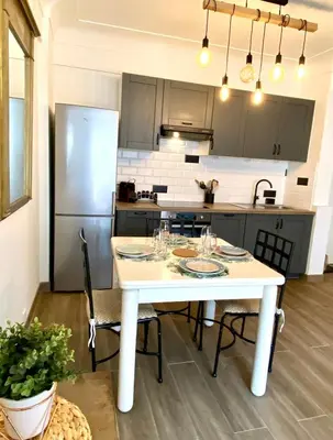 a kitchen with a white table and a refrigerator at Cosy Californie in Nice