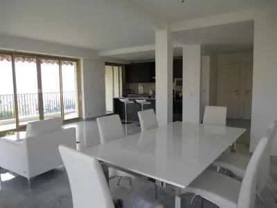 a dining room with a white table and white chairs at NICE BAIE DES ANGES in Nice