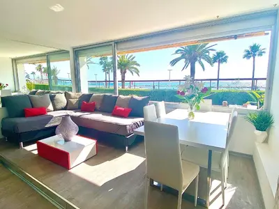 a living room with a couch and a table at Magnifique appartement les pieds dans l’eau à Nice in Saint-Laurent-du-Var