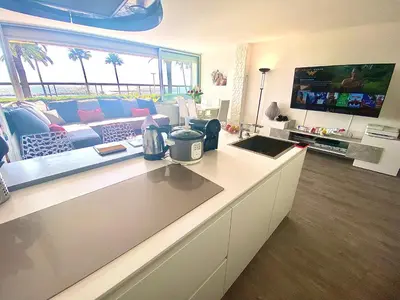 a living room with a couch and a tv at Magnifique appartement les pieds dans l’eau à Nice in Saint-Laurent-du-Var