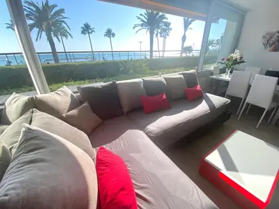 a living room with a couch with a view of the ocean at Magnifique appartement les pieds dans l’eau à Nice in Saint-Laurent-du-Var