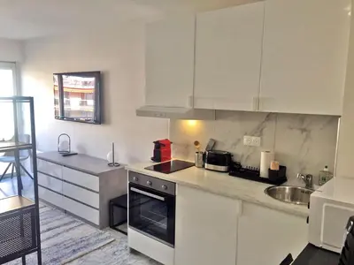 a kitchen with white cabinets and a sink at Beachfront Studio on Promenade des Anglais in Nice