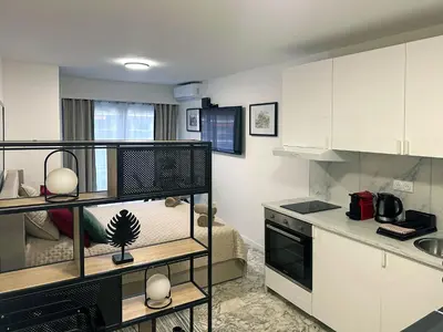 a kitchen with white cabinets and a black and white kitchen at Beachfront Studio on Promenade des Anglais in Nice