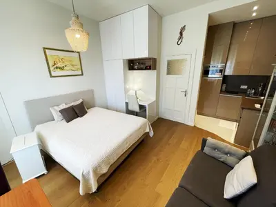 a bedroom with a white bed and a couch at Ezevacances Studio Capuccino vue mer 5 mn plage 7 mn gare Wifi in Èze