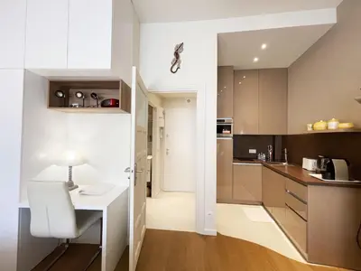 a small kitchen with a white table and a desk at Ezevacances Studio Capuccino vue mer 5 mn plage 7 mn gare Wifi in Èze