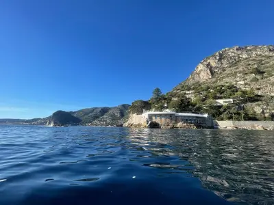 a woman in a hat on a boat in the water at Ezevacances Studio Capuccino vue mer 5 mn plage 7 mn gare Wifi in Èze