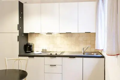 a kitchen with white cabinets and a sink at Jolie studio - Proche Promenade des anglais in Nice