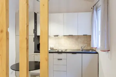 a kitchen with white cabinets and a sink at Jolie studio - Proche Promenade des anglais in Nice